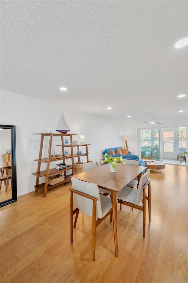 dining space featuring recessed lighting, a textured ceiling, and light wood finished floors