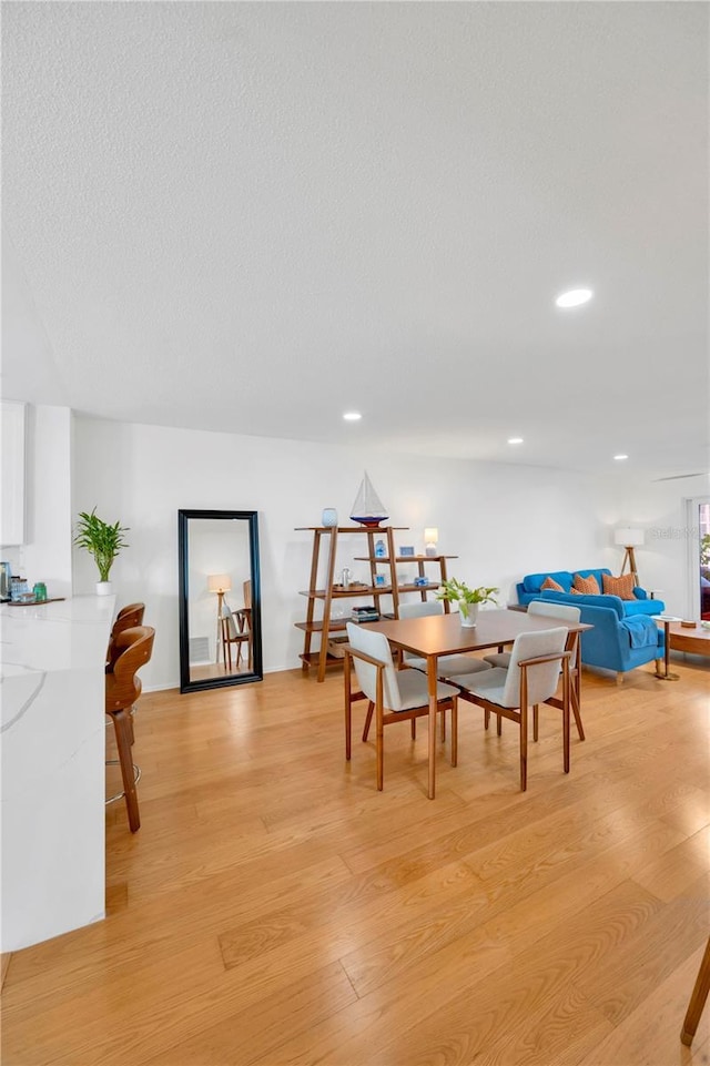 dining room featuring recessed lighting, a textured ceiling, and light wood finished floors