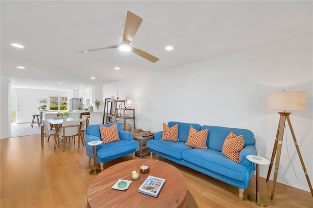 living room featuring ceiling fan, light wood-style flooring, and recessed lighting