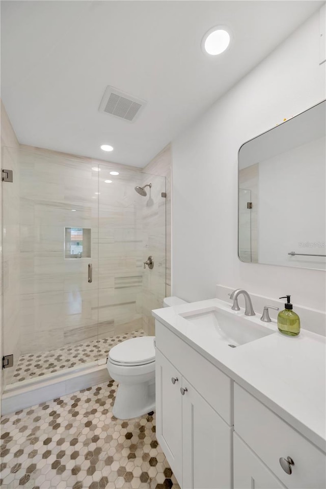 bathroom with recessed lighting, visible vents, toilet, a stall shower, and vanity