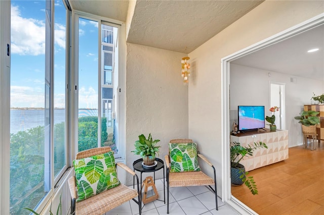 balcony with a water view and a sunroom