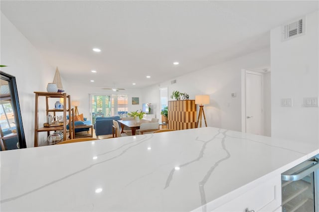 1600 1st Ave W Unit 102A, Bradenton, FL 34205 - kitchen featuring wine cooler, healthy amount of natural light, recessed lighting, ceiling fan, and light stone countertops