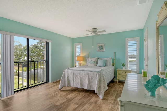 bedroom with ceiling fan, a textured ceiling, and wood finished floors