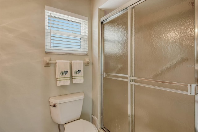 full bathroom with toilet and a shower with shower door