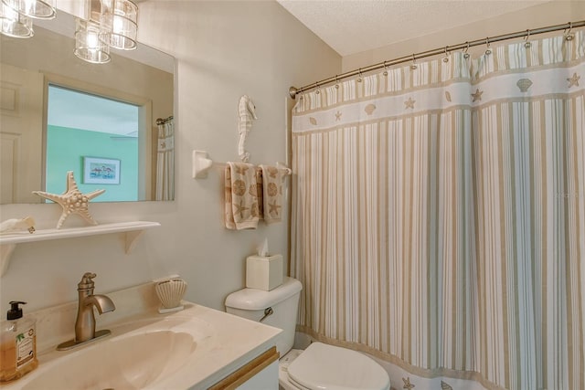 bathroom with a textured ceiling, toilet, and vanity