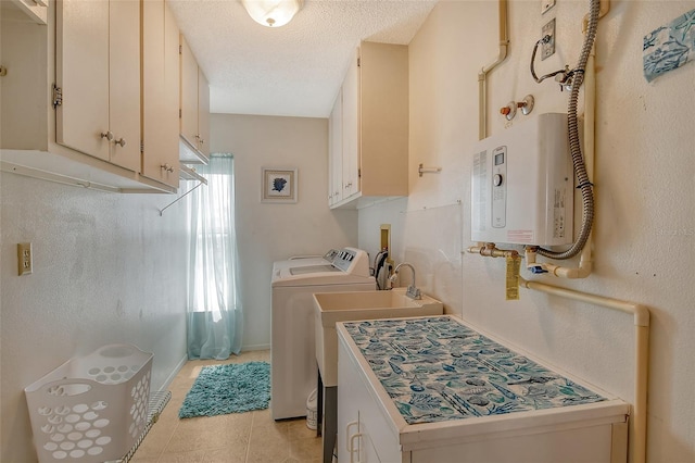 clothes washing area featuring a textured ceiling, light tile patterned flooring, tankless water heater, washer and dryer, and cabinet space