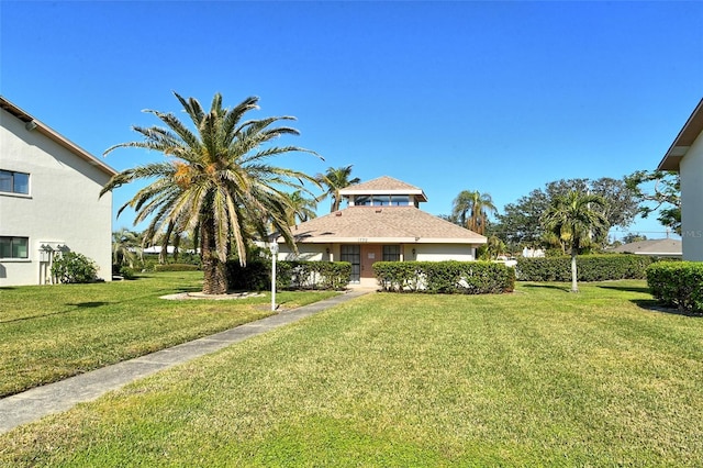 view of front of home featuring stucco siding and a front yard