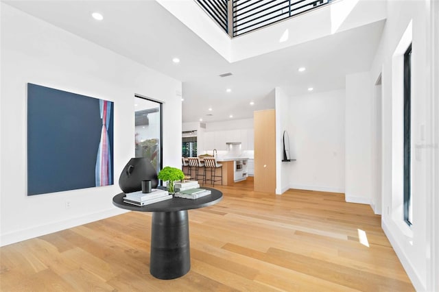 foyer with light wood-style floors, recessed lighting, and baseboards