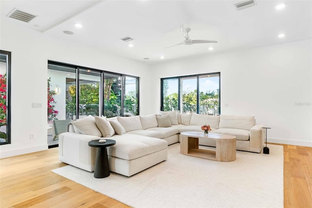 living area with light wood-type flooring, visible vents, and recessed lighting