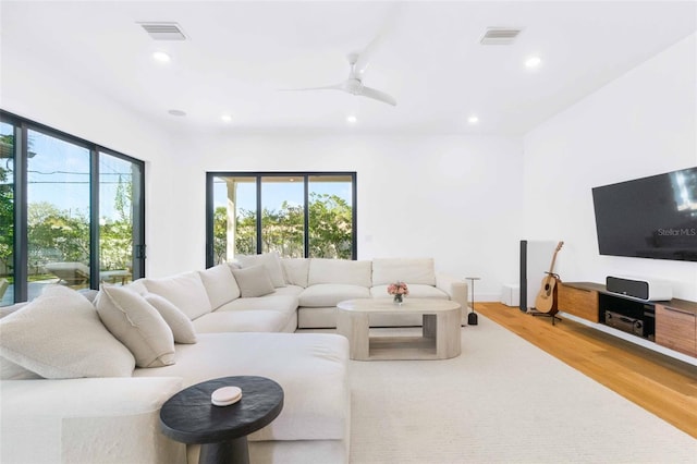 living room featuring ceiling fan, wood finished floors, visible vents, and recessed lighting