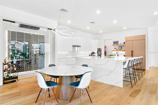 dining space with visible vents, light wood-style flooring, and recessed lighting