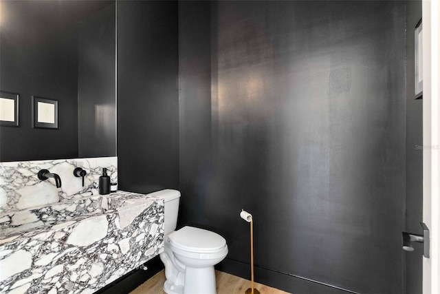 bathroom featuring toilet and wood finished floors