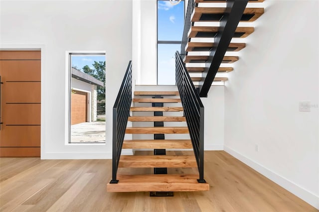 staircase featuring wood finished floors and baseboards