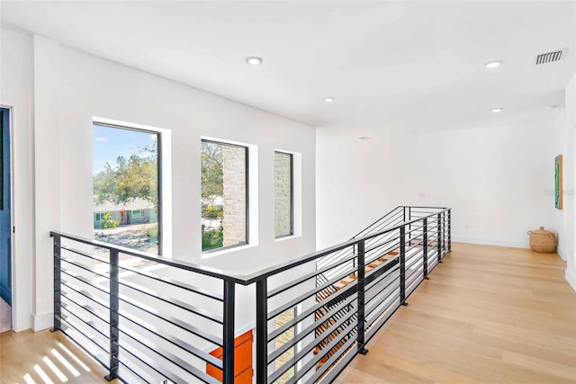 hall with recessed lighting, visible vents, an upstairs landing, light wood-type flooring, and baseboards