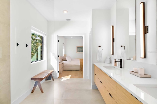 ensuite bathroom featuring double vanity, recessed lighting, ensuite bathroom, a sink, and tile patterned floors