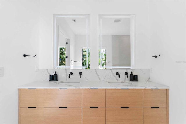 full bath with double vanity, visible vents, and a sink