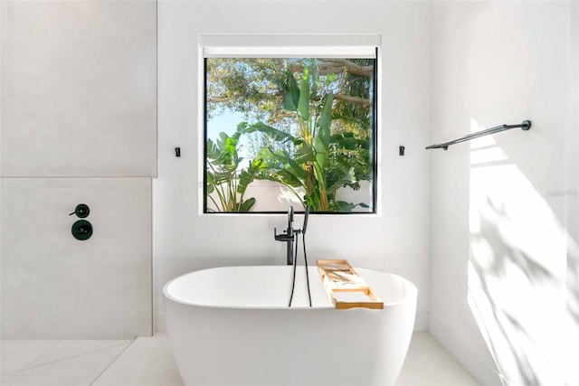 bathroom with a soaking tub and tile patterned flooring