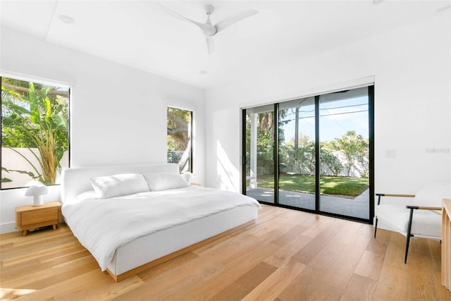 bedroom featuring access to exterior, light wood finished floors, and a ceiling fan