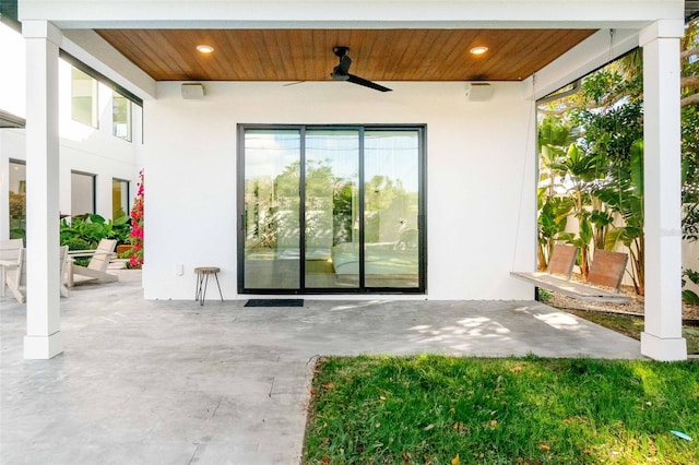 view of exterior entry with a patio, a ceiling fan, and stucco siding