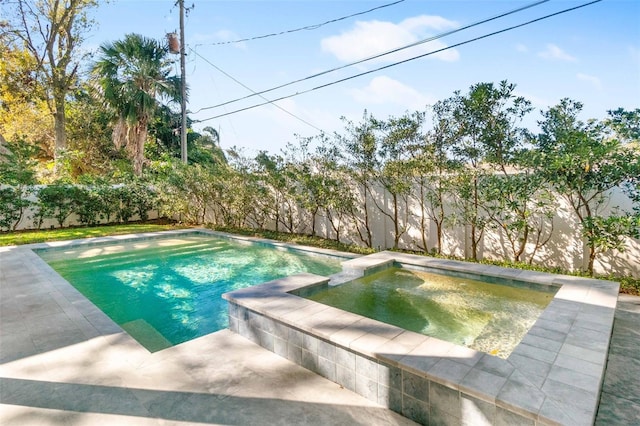 view of swimming pool featuring a patio area, a fenced backyard, and a pool with connected hot tub