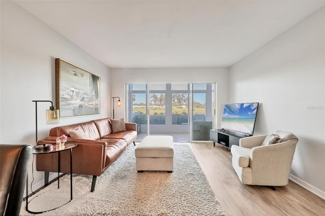 living area with baseboards and wood finished floors