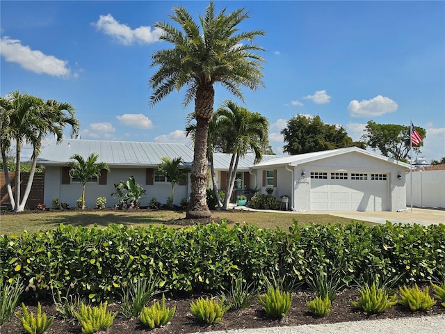 ranch-style home featuring stucco siding, concrete driveway, an attached garage, and fence