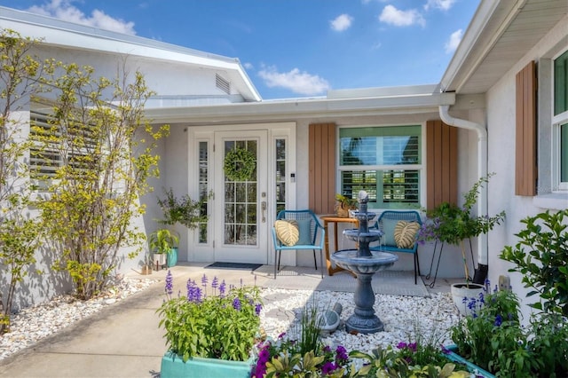 doorway to property featuring stucco siding