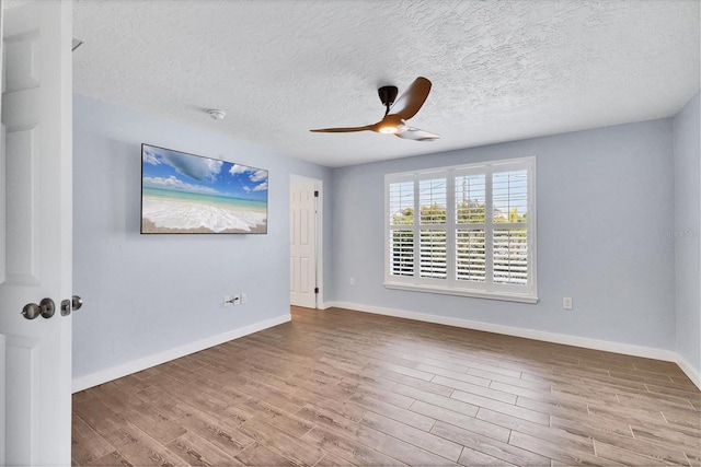 unfurnished room featuring a ceiling fan, a textured ceiling, baseboards, and wood finished floors