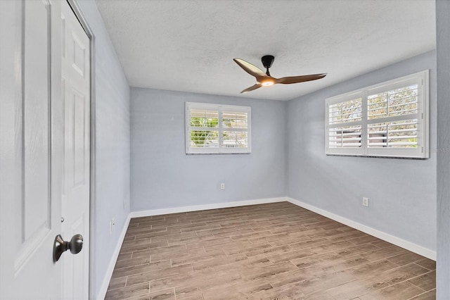 unfurnished bedroom with baseboards, ceiling fan, wood finished floors, a textured ceiling, and a closet