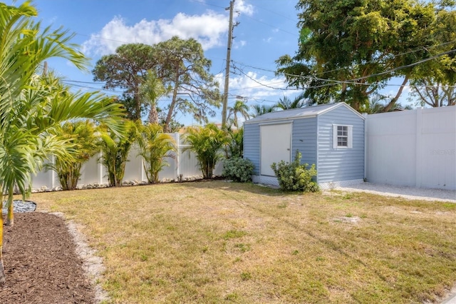 view of yard featuring a fenced backyard, an outdoor structure, and a shed