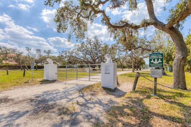 exterior space featuring a gate, fence, and a lawn