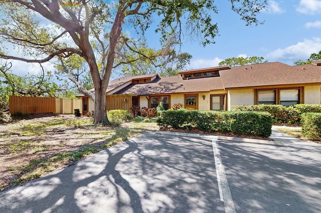 view of front of home featuring stucco siding and fence