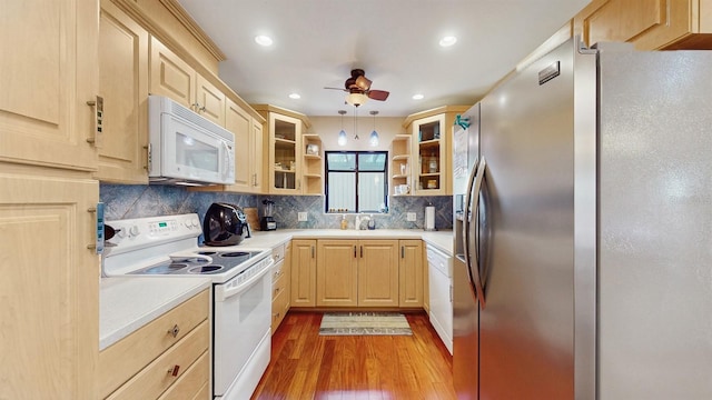 kitchen featuring white appliances, wood finished floors, light brown cabinets, open shelves, and light countertops