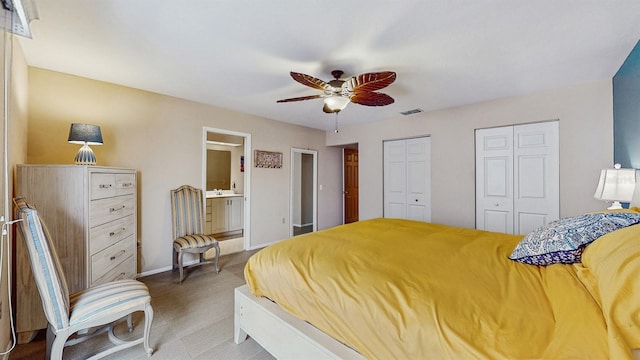 bedroom with visible vents, ceiling fan, baseboards, multiple closets, and ensuite bathroom