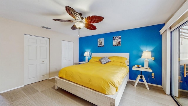 bedroom featuring visible vents, two closets, baseboards, carpet flooring, and a ceiling fan