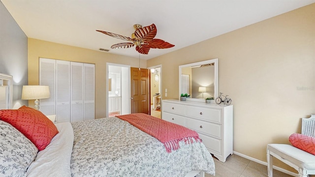 bedroom featuring visible vents, baseboards, ensuite bathroom, a closet, and a ceiling fan