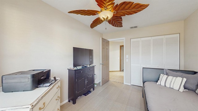 bedroom with visible vents, baseboards, ceiling fan, light carpet, and a closet