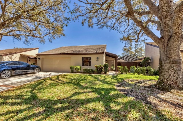 view of front facade featuring a front lawn, fence, concrete driveway, stucco siding, and a garage