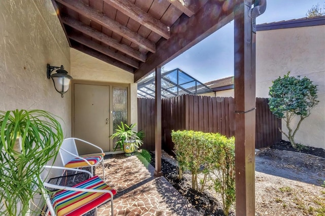 view of patio featuring a lanai and fence