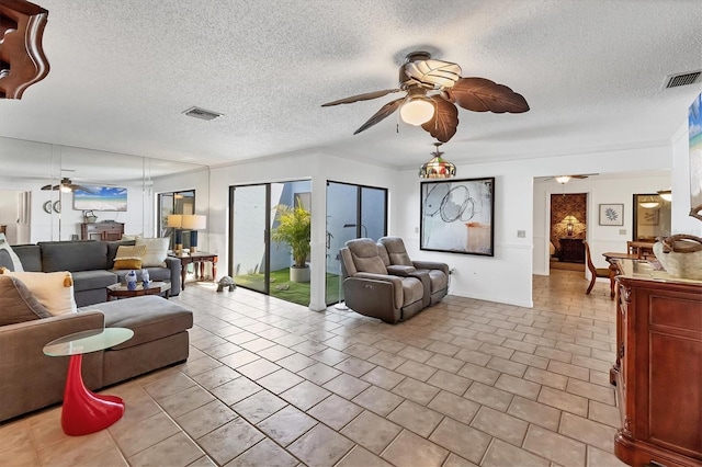 living area with visible vents, a textured ceiling, and ceiling fan