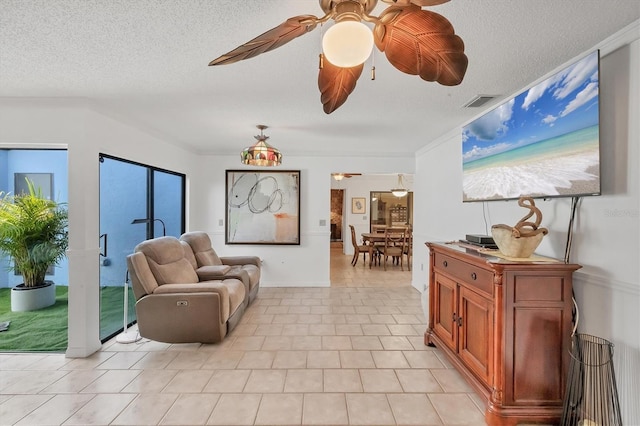 sitting room featuring visible vents, a textured ceiling, and ceiling fan