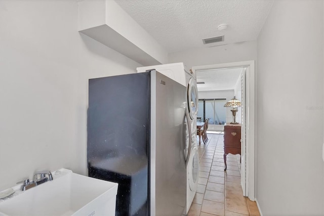 corridor with a sink, a textured ceiling, and light tile patterned floors