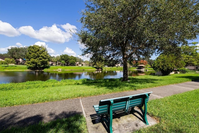 view of community with a yard and a water view