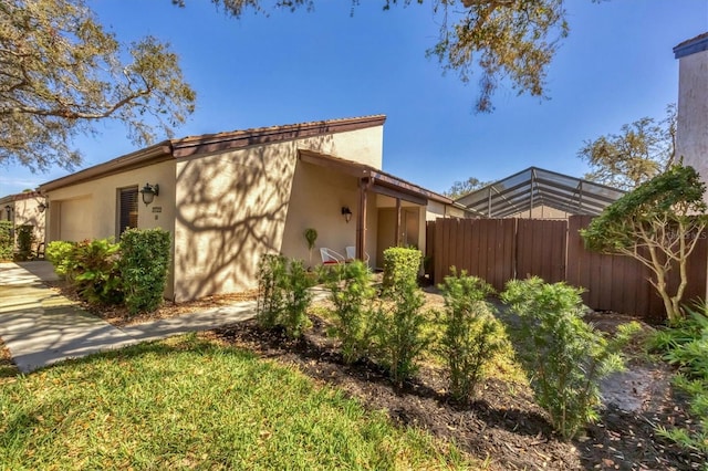 view of home's exterior featuring stucco siding and fence