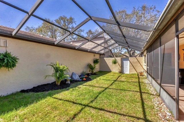 view of yard with a lanai and fence