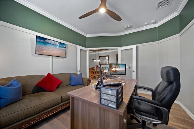 home office featuring ceiling fan, visible vents, wood finished floors, and ornamental molding