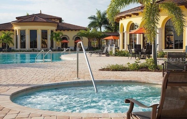 view of swimming pool featuring a patio area and a hot tub