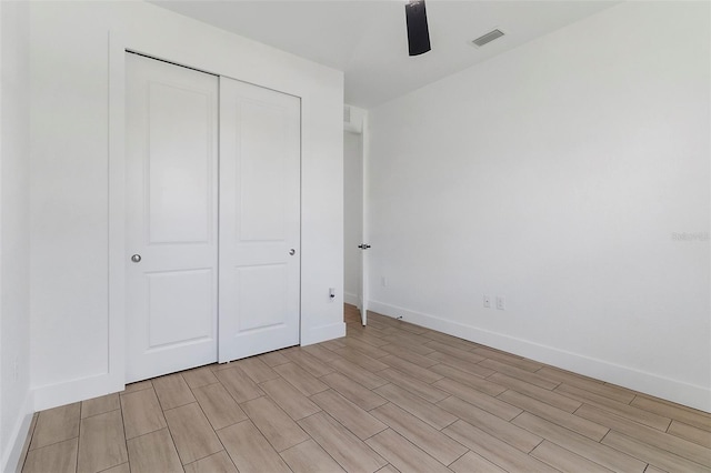 unfurnished bedroom with visible vents, baseboards, ceiling fan, wood finish floors, and a closet