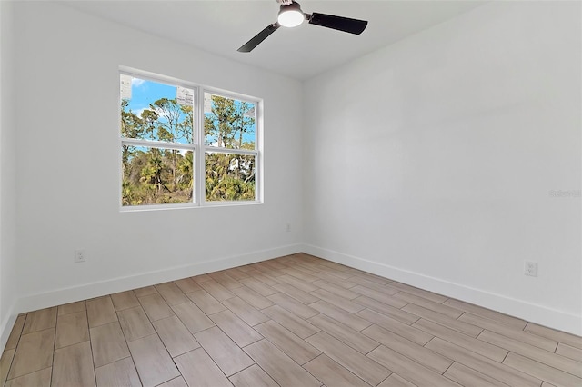 empty room with ceiling fan, a wealth of natural light, and baseboards