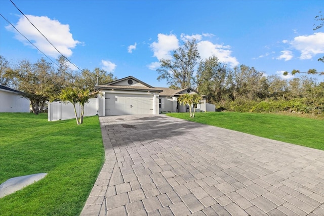 ranch-style house with a front yard, decorative driveway, fence, and an attached garage